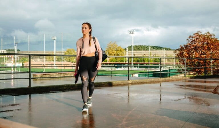 Female athlete with cropped-sweatshirts and high-waisted leggings with gym bag and walking sneakers for training Female athlete with cropped-sweatshirts and high-waisted leggings with gym bag and walking sneakers for training